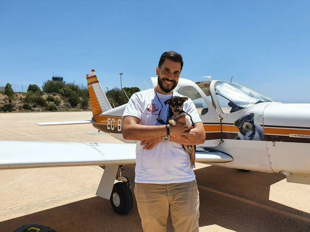 Piloto de Patas y Pilotos con Gea en brazos junto al avión